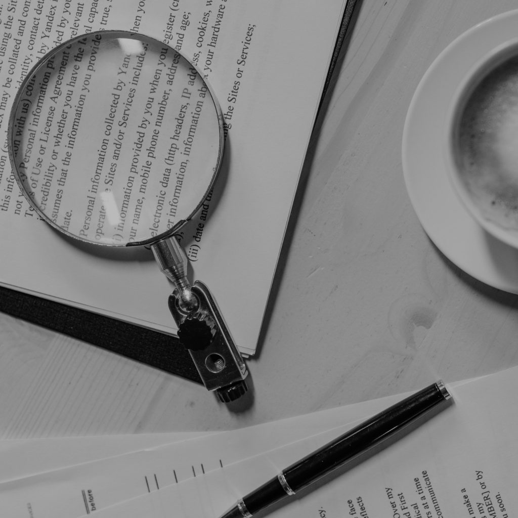 Strategic audit, reports on table with magnifying glass